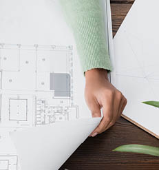 cropped view of african american architect near blueprint and smartphone with blank screen, banner