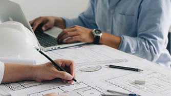 Engineer constuction and interior team dissussing in the office. and angineer working drawing on blueprint meeting for project working with a partner on model building plans at table in a modern office.construction concept.  