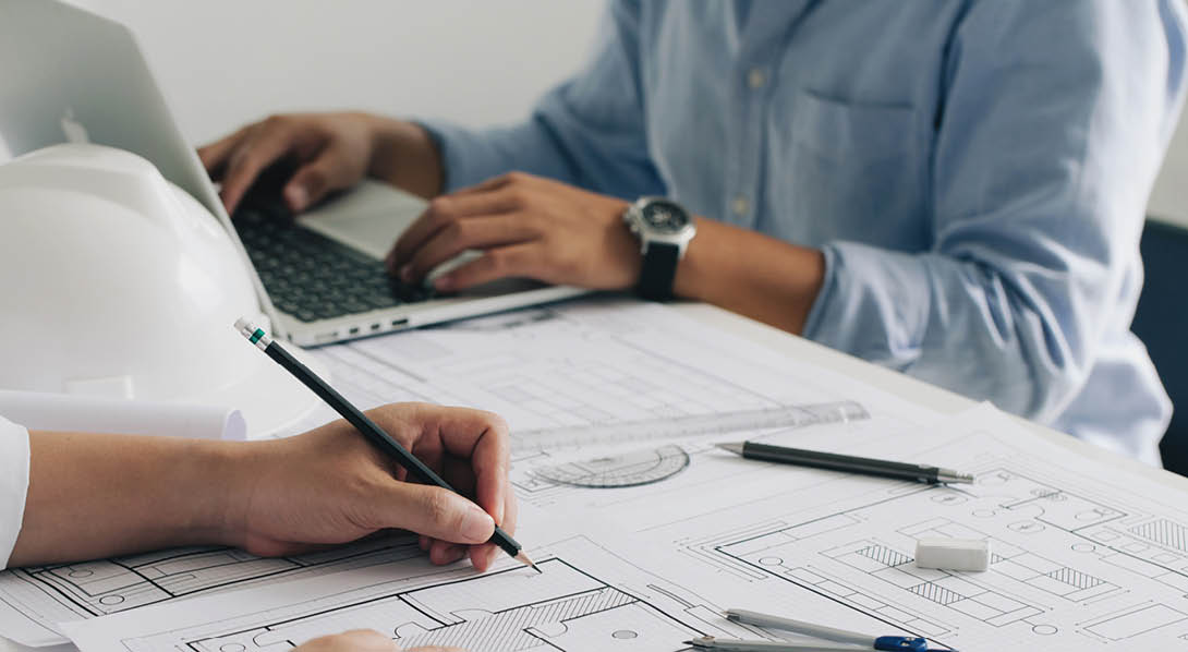 Engineer constuction and interior team dissussing in the office. and angineer working drawing on blueprint meeting for project working with a partner on model building plans at table in a modern office.construction concept.  